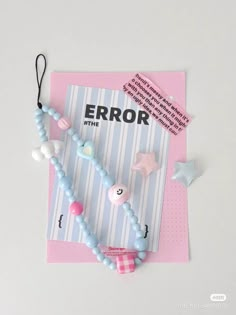 a pink and blue book with some beads on top of it next to a tag that says error