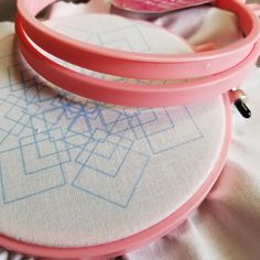 a pair of pink hooplets sitting on top of a white cloth covered tablecloth