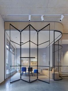 an open room with glass walls and blue chairs