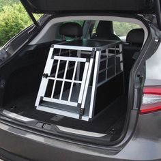 the back end of a car with its hatch open and dog cage in it's trunk