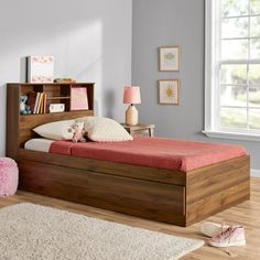 a child's bedroom with a bookcase bed and rugs on the floor