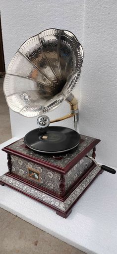 an old record player sitting on top of a wooden box next to a white wall