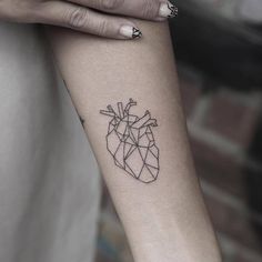 a woman's arm with a heart tattoo on it