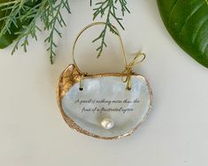 a ceramic ornament with a quote on it next to some plants and leaves