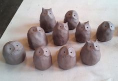 nine clay owls sitting next to each other on a table