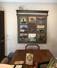 a wooden table topped with a quilted wall hanging