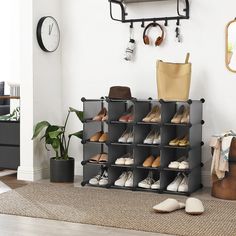 a shoe rack with several pairs of shoes on it next to a clock and plant