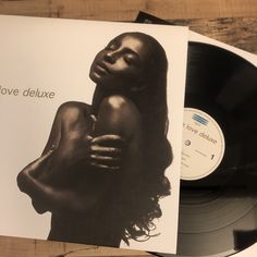 a vinyl album with an image of a woman hugging her head on top of a wooden table