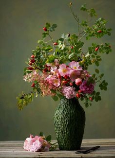 a vase filled with lots of flowers on top of a table