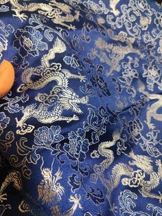 an orange piece of fruit sitting on top of a blue and white cloth with dragon designs