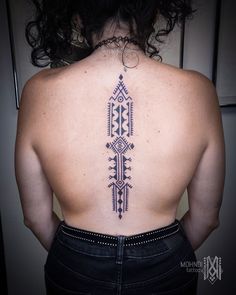 the back of a woman's upper body with an intricate tattoo design on it