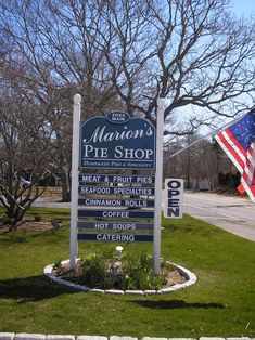 a sign for the marion's pie shop in front of a flag and tree