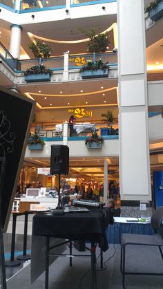 the inside of a shopping mall with tables and chairs in front of an open air balcony