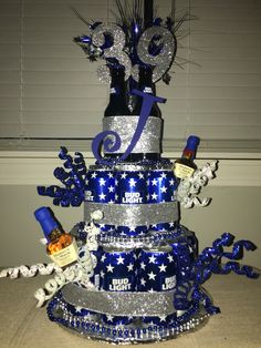 a large blue and silver cake with stars on it's side, surrounded by confetti