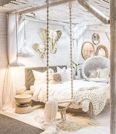 a bedroom with white bedding and decorations on the walls, along with hanging lights