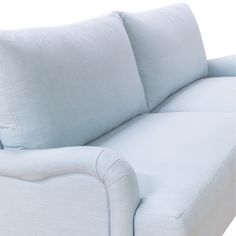 a white couch with two pillows on it's back and one arm facing the camera