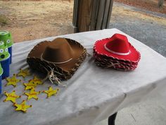 two hats are sitting on a table with stars around them and one has a straw hat