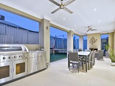 an outdoor kitchen and dining area with stainless steel appliances