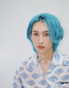 a young man with blue hair wearing a shirt