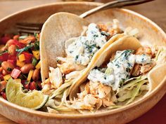 two tacos with chicken and vegetables in a bowl