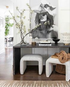 two white stools in front of a black and white painting