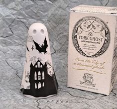 a black and white ghost figurine next to a box