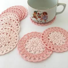 pink crocheted coasters next to a coffee cup