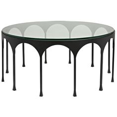 an oval glass table with black legs and white circles on the top, against a white background