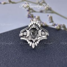 a diamond ring sitting on top of a blue surface next to some purple and white flowers