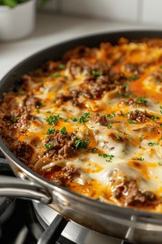 a close up of a casserole with meat and cheese in a pan on the stove