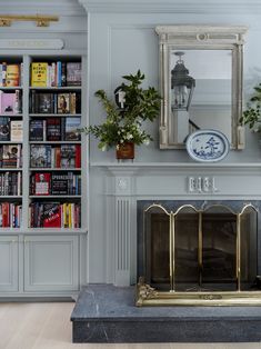 a living room with a fire place and bookshelves