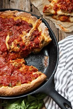 a deep dish pizza in a cast iron skillet with one slice missing from it