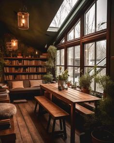 a wooden table sitting in front of a window next to a book shelf filled with books