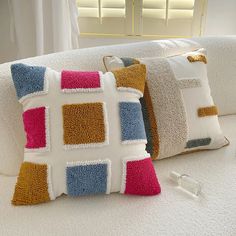 two pillows are sitting on a white couch