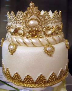 a white cake with gold decorations on top