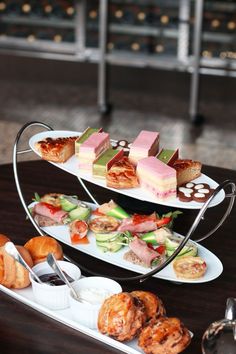 three tiered trays filled with different types of food on top of a table