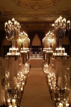 the aisle is lined with candles and chandeliers