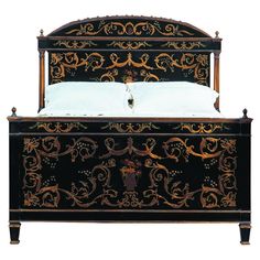 an ornate black and gold bed frame with white pillows