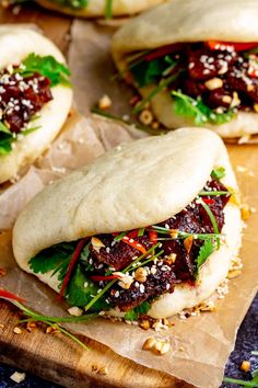 several pita breads with various toppings on top of each one, sitting on a cutting board