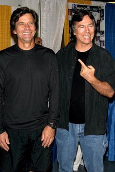 two men standing next to each other smiling