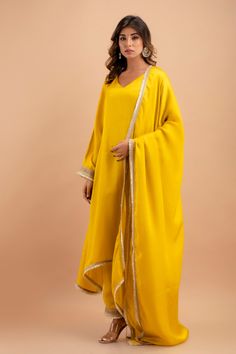 Step into the world of timeless elegance with our handcrafted Silk Kurta Set, a perfect blend of traditional grace and contemporary style. This exquisite ensemble includes a stunning kurta, a pair of breezy palazzos, and a flowing dupatta, each piece accentuated with delicate Gota lace attachments that add a touch of golden shimmer to your every move. The kurta, measuring an impressive 48 inches in length, gracefully drapes over your form, while the palazzos offer a comfortable 39-inch length fo Yellow Anarkali Palazzo Set With Embroidered Border, Yellow Embroidered Palazzo Set For Festivals, Yellow Palazzo Set With Embroidered Border For Diwali, Diwali Yellow Palazzo Set With Embroidered Border, Diwali Yellow Embroidered Palazzo Set, Elegant Yellow Palazzo Set With Traditional Drape, Elegant Yellow Palazzo Set For Eid, Elegant Yellow Palazzo Set With Dabka Work, Elegant Yellow Salwar Kameez With Gota Work