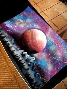 a table with a painting on it that has an image of the planets in space