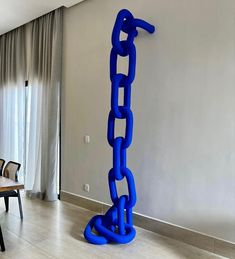 a large blue chain is in the middle of a dining room table with chairs around it