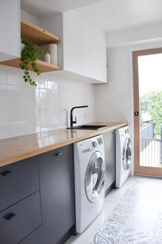 a washer and dryer sitting in a kitchen next to an open door that leads to a balcony