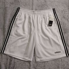 Men's Adidas Athletic Shorts. Classic Three Stripes Down Each Leg. Small Logo On Left Thigh. Elastic Waistband With Drawstring. New With Tags White Adidas Sports Shorts, Adidas Sporty White Athletic Shorts, White Athletic Shorts With Three Stripes For Summer, White Three Stripes Athletic Shorts For Sports, White Three Stripes Athletic Shorts, White Three-stripe Sports Shorts, Adidas White Athletic Shorts With Moisture-wicking, Adidas White Bottoms With Three Stripes, Adidas White Cotton Athletic Shorts