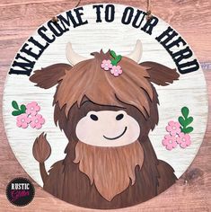 a wooden sign that says welcome to our herd with an image of a yak