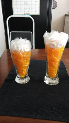 two glasses filled with liquid sitting on top of a table