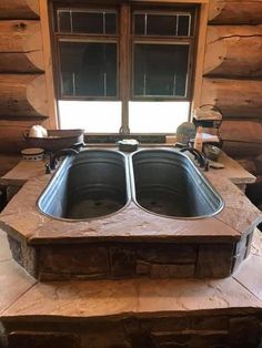 a kitchen with two sinks in front of a window and stone counter tops on each side