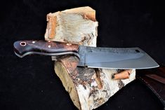 a knife sitting on top of a piece of wood