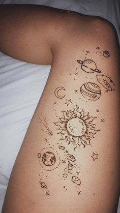 the back of a woman's stomach with sun and planets drawn on her side